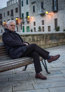 Carlo Mazza è nato a Bari nel 1956, dove ha sempre vissuto. Lavora in banca da 35 anni e si è occupato di organizzazione e gestione dei rischi. Tra i propri interessi, ha praticato attività politica e ha coltivato la scrittura teatrale, dedicandosi alla drammaturgia di ispirazione religiosa. Con il personaggio di Antonio Bosdaves, ispirato ai suoi trascorsi militari, ha pubblicato per la collezione Sabot/age delle Edizioni e/o, i polizieschi “Lupi di fronte al mare” (2011), incentrato sulle relazioni tra politica, finanza e sanità, finalista al “Festival Mediterraneo del Giallo e del Noir” 2012 e tradotto in lingua spagnola dalle Ediciones Seronda; e “Il cromosoma dell’orchidea” (2014). Sullo sfondo di una partita che contrappone angeli e demoni e ha come posta la salvezza ambientale, agiscono personaggi vibranti e intensi, animati da lucenti passioni o soggiogati dalla carnalità, in una corsa scintillante verso la rivelazione finale. Il tutto partendo dal suicidio (presunto) di un amico del protagonista, politico votato alla salvezza dell’ambiente naturale e, quindi, della propria terra. Una vicenda che narra la realtà accecata del Sud, con lo sguardo consapevole di chi ne fa parte e ha scelto di restarvi. «Il cognome del protagonista – spiega Carlo Mazza - rimanda ai miei ricordi adolescenziali: c’era un giocatore argentino del Verona che si chiamava così. Il nome del Capitano, viene da lì. Mi piaceva la musicalità ondosa del suono. A dispetto della provenienza, il mio capitano ama poco il gioco di squadra. D'altra parte, e cito Visconti, i corvi volano a stormi, l'aquila sempre da sola. L’intenzione è di scrivere un altro romanzo con Bosdaves, per comporre una trilogia». Lo stile di scrittura di Carlo Mazza è stato oggetto anche di una ricerca linguistica (“Puglia in Noir” di Maria Carosella, Società di Storia patria per la Puglia, 2013).